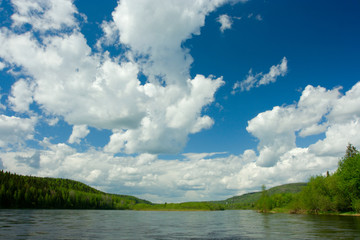 Summer landscape. Clouds above the river.