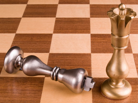 Metal Chess Pieces On Wooden Board