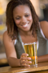 Young woman enjoying a beer at a bar
