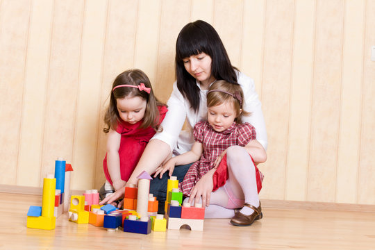 Mother and daughters play with bright geometric toys