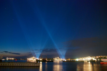 Fototapeta na wymiar Searchlights in the sky above the bay.