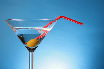 Martini glass with olive and red straw