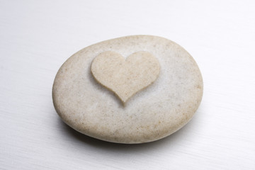 a stone with an engraved heart on a metal surface