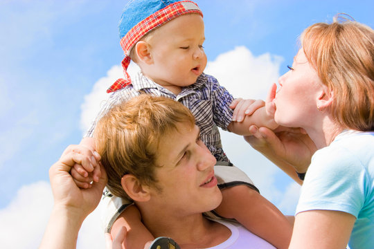 Happy Family With Baby Over Blue Sky