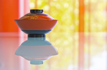 Japanese bowl and reflection on vivid ground