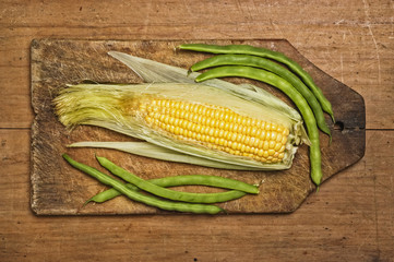 Green beans and corn on wooden table
