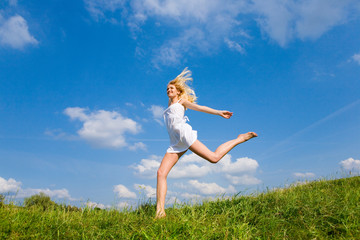 Happy woman is running on a field
