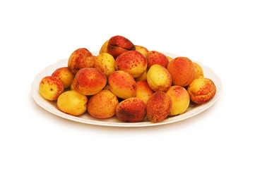 Naklejka na ściany i meble Many colourful red apricots in the plate
