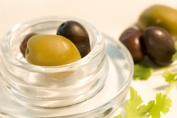 Black and green olives in glass bowl