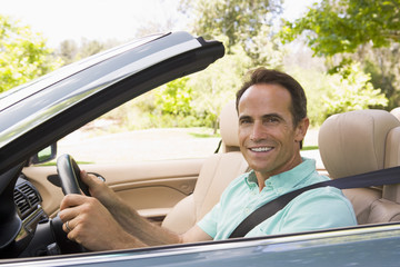 Man in convertible car smiling