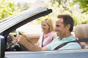 Couple in convertible car smiling