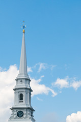 White church steeple with clock and weather vane