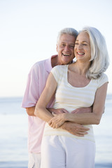 Obraz premium Couple at the beach embracing and smiling