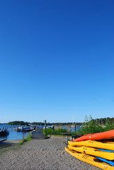 Kayaks on shore with blue sky