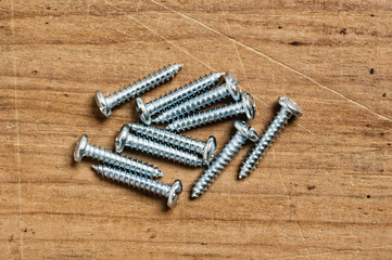 Assorted screws on wood, close up shot.
