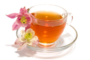 Transparent teacup with tea and flowers