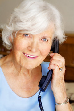 Seniorin mit Telefonh&ouml;rer  