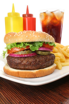 Hamburger served with french fries and soda close-up