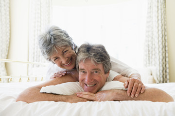 Couple lying on bed together smiling