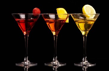 Three colorful cocktails with fruits on black background