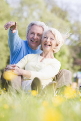 Couple relaxing outdoors pointing and smiling