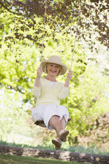 Woman on a swing outdoors smiling