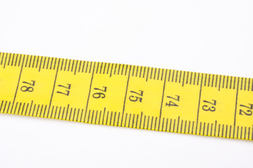 yellow measuring tape used by tailors on white
