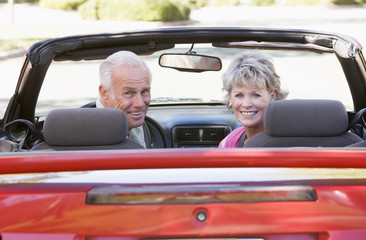 Couple in convertible car smiling