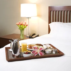 Poster Breakfast tray on white bed. © iofoto