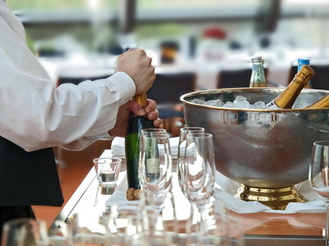 kellner bereitet sektflasche bankett gastronomie