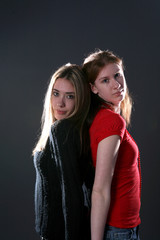 Fototapeta na wymiar two teenage sisters standing back to 