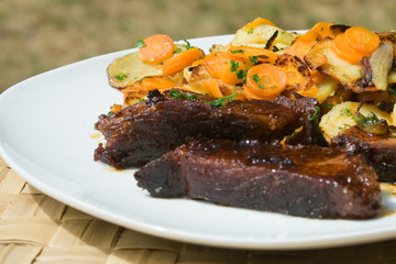 assiette de porc caramèlisé et petits légumes