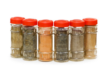 Various spices in bottles isolated on white