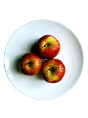 three apples at plate