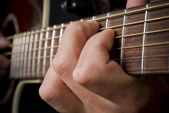 Guitarist hand playing acoustic guitar