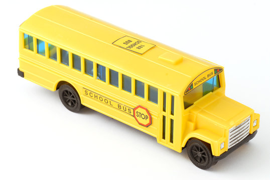 plastic yellow toy school bus on white background