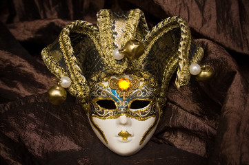 venetian mask on brown fabric