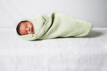 Isolated newborn wrapped up in a soft blanket