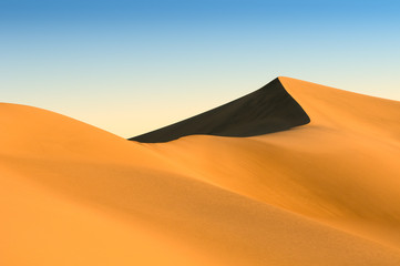 sand dunes over blue sky