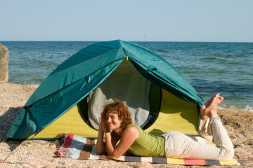 Smniling girl lie near of her tent