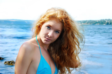 portrait of beatiful redhead girl over blue waters