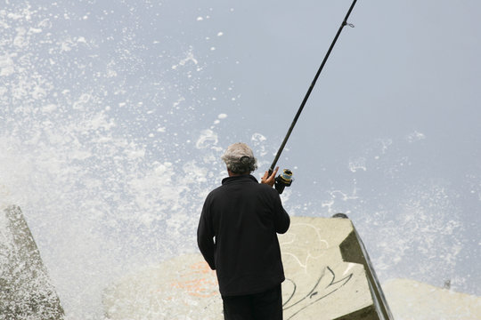 Pêcheur En Action Au Bors De La Mer