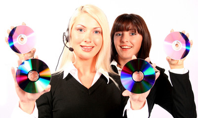 Two young smiling beautiful women holding cds dvd vcd
