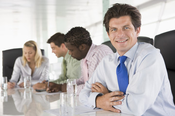 Fototapeta premium Four businesspeople in a boardroom smiling