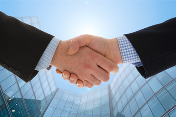Handshake with modern skyscrapers as background