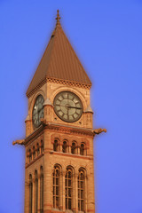 old clock brick brown school tower on a bright blue sky
