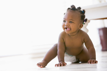 Baby crawling indoors smiling - obrazy, fototapety, plakaty
