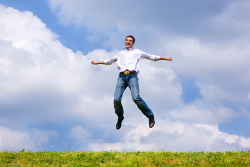 Happy man is jumping on a field