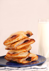 Stack of blueberry turnovers with milk