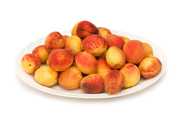 Many colourful red apricots in the plate